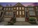 Attractive brick townhouse exterior at dusk with attached garage at 5104 Leeshire Se Trl # 64, Atlanta, GA 30339