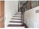 Elegant foyer with wood stairs, featuring decorative white wainscoting and a wood railing at 5104 Leeshire Se Trl # 64, Atlanta, GA 30339