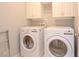 Functional laundry room featuring a washer, dryer, and overhead cabinets at 4703 Legacy Cove Ln, Smyrna, GA 30126
