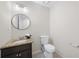 Bathroom with granite countertop, modern fixtures, and a round mirror at 4390 Allgood Pl, Stone Mountain, GA 30083