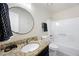 Bright bathroom with a granite countertop, round mirror, and a shower over tub at 4390 Allgood Pl, Stone Mountain, GA 30083