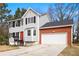 Charming two-story home with gray siding, black shutters, red front door, and attached two car garage at 4390 Allgood Pl, Stone Mountain, GA 30083