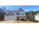 Two story house with gray siding, stone accents and a two-car garage at 6268 Odum Cir, Covington, GA 30014