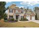 Two story house with stone and shingle accents, two car garage, and landscaped yard at 2005 Creek Pointe Way, Villa Rica, GA 30180