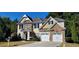 Two story house with stone and shingle accents, two car garage, and landscaped yard at 2005 Creek Pointe Way, Villa Rica, GA 30180