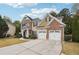 Two story house with stone and shingle accents, two car garage, and landscaped yard at 2005 Creek Pointe Way, Villa Rica, GA 30180