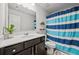 Well-lit bathroom features large vanity and modern fixtures and blue striped shower curtain at 2527 Dayview Ln, Atlanta, GA 30331