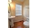 Charming half bathroom with a pedestal sink, wood floors, and a window providing natural light at 2192 Landing Walk Dr, Duluth, GA 30097