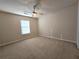 Neutral bedroom featuring carpet, ceiling fan, and ample natural light from the window at 2192 Landing Walk Dr, Duluth, GA 30097