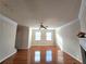 Airy living room with wood floors, a ceiling fan, ample natural light from two windows, and a view of the fireplace at 2192 Landing Walk Dr, Duluth, GA 30097