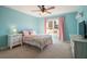 Cozy bedroom with light blue walls, a ceiling fan, and plenty of natural light at 6610 Wesley Trail Holw, Cumming, GA 30028