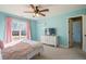 Charming bedroom with light blue walls, a ceiling fan, and access to a hallway at 6610 Wesley Trail Holw, Cumming, GA 30028