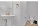 Small powder room with pedestal sink, toilet and gold fixtures at 11988 Lovejoy Crossing Pl, Hampton, GA 30228