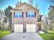 Charming two-story home with a two car garage, brick facade, and manicured lawn at 11988 Lovejoy Crossing Pl, Hampton, GA 30228