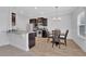 Eat-in kitchen with dark cabinets, stainless steel appliances, and an island at 11988 Lovejoy Crossing Pl, Hampton, GA 30228