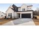 Two-story farmhouse with a black and white exterior, long driveway and landscaping at 4265 Haynes Cir, Snellville, GA 30039