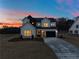 Two-story farmhouse at dusk, showcasing the exterior lights and landscaping at 4265 Haynes Cir, Snellville, GA 30039