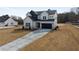 Two-story farmhouse with a black and white exterior, long driveway and landscaping at 4265 Haynes Cir, Snellville, GA 30039