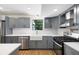 Renovated kitchen featuring gray shaker cabinets, marble backsplash, and a farmhouse sink at 9106 Kelly Ct, Jonesboro, GA 30236