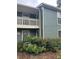 View of the exterior of a two-story condo building with lush landscaping and a balcony at 2824 Vinings Central Se Dr # 146, Atlanta, GA 30339