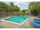 Beautiful community pool featuring waterfalls, lounge chairs, umbrellas, and lush landscaping at 2824 Vinings Central Se Dr # 146, Atlanta, GA 30339