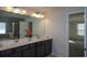 Double vanity bathroom with a large mirror and a view of the bedroom at 309 Bowfin Trl, Mcdonough, GA 30253