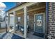 Covered front porch with rocking chairs and brick exterior at 309 Bowfin Trl, Mcdonough, GA 30253