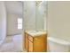 Bathroom with toilet and vanity with wood cabinets adjacent to doorway to bedroom with window at 2878 Norfair Loop, Lithonia, GA 30038