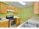 The kitchen features an electric range, wooden cabinets, stainless steel sink, and an oven at 2878 Norfair Loop, Lithonia, GA 30038