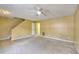 View of the living room area with a ceiling fan, natural lighting, and stairs in the background at 2878 Norfair Loop, Lithonia, GA 30038
