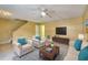 Bright living room features a ceiling fan, and comfortable seating, enhanced by a blue accent rug at 2878 Norfair Loop, Lithonia, GA 30038