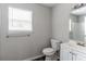 Clean bathroom with a window, white vanity, toilet, and neutral wall color at 804 Thomasville Se Blvd, Atlanta, GA 30315