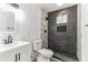 Modern bathroom with dark gray tiled shower and white vanity at 1318 Graymont Sw Dr, Atlanta, GA 30310