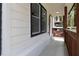 Front porch with white siding, dark window frames, and wooden railing at 1318 Graymont Sw Dr, Atlanta, GA 30310