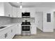 Modern white kitchen with stainless steel appliances and gray flooring at 1318 Graymont Sw Dr, Atlanta, GA 30310