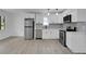 Modern white kitchen with stainless steel appliances and gray flooring at 1318 Graymont Sw Dr, Atlanta, GA 30310