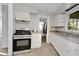 Galley kitchen featuring stainless steel appliances, white cabinets, and neutral countertops at 1405 Pinehurst Sw Dr, Atlanta, GA 30311