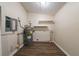 Functional utility room with wood-look flooring, water heater, and mounted shelving at 16 Bromack Se Dr, Atlanta, GA 30315