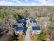 Aerial view of a residential complex with blue solar panels on the roofs, surrounded by lush trees at 105 Weatherford Pl, Roswell, GA 30075