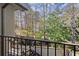 Balcony overlooking wooded backyard with a brick patio and lush landscaping at 105 Weatherford Pl, Roswell, GA 30075