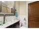 Bathroom with a decorative clear glass sink, mosaic countertops, and a wood-framed door at 105 Weatherford Pl, Roswell, GA 30075