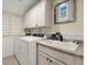 Well-equipped laundry room with modern washer, dryer, ample cabinetry, and a utility sink at 105 Weatherford Pl, Roswell, GA 30075
