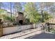 Inviting outdoor patio featuring a brick fireplace, comfortable seating, and a serene wooded backdrop at 105 Weatherford Pl, Roswell, GA 30075