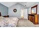 Inviting main bedroom with blue walls, carpet, vaulted ceilings, dresser, mirror and an ensuite bathroom, a private retreat at 5732 Village Loop, Fairburn, GA 30213