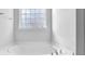 Corner of a white soaking tub in front of a window at 3490 Buffington Ln, Cumming, GA 30040
