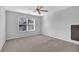 Neutral bedroom featuring a ceiling fan, a large window with blinds, and plush gray carpeting at 3490 Buffington Ln, Cumming, GA 30040