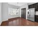 Bright dining area with hardwood floors, large window, and stainless steel refrigerator at 3490 Buffington Ln, Cumming, GA 30040
