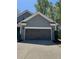 Attached two-car garage with a concrete driveway and a gray exterior at 3490 Buffington Ln, Cumming, GA 30040