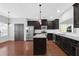 Modern kitchen featuring dark cabinets, stainless steel appliances, and an island at 3490 Buffington Ln, Cumming, GA 30040