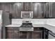 Modern kitchen features stainless steel appliances, granite countertops, and dark wood cabinetry at 3490 Buffington Ln, Cumming, GA 30040